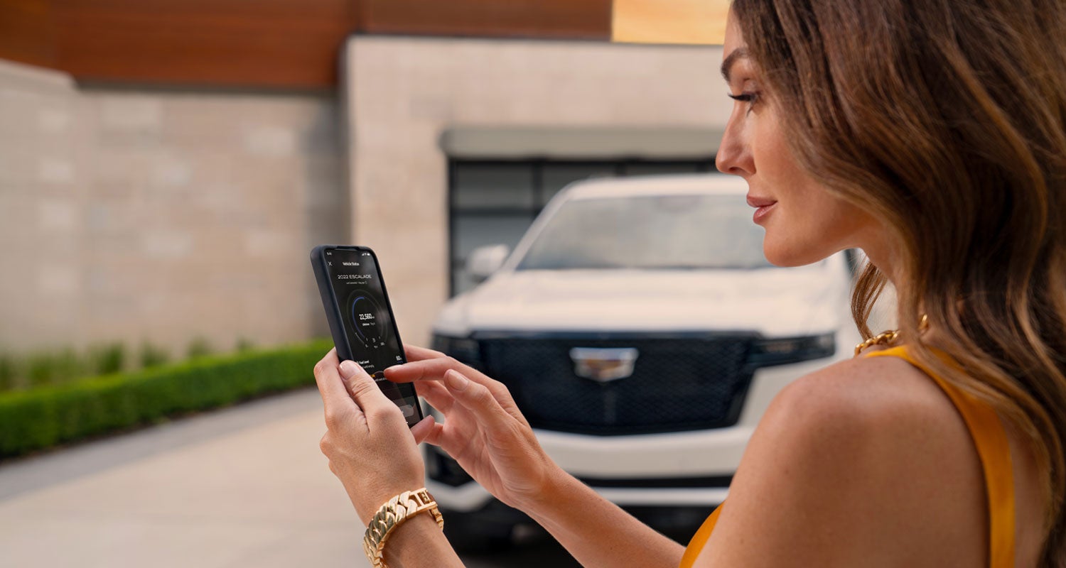 lady checking her mobile with a Cadillac vehicle background | Stephen Cadillac in Bristol CT